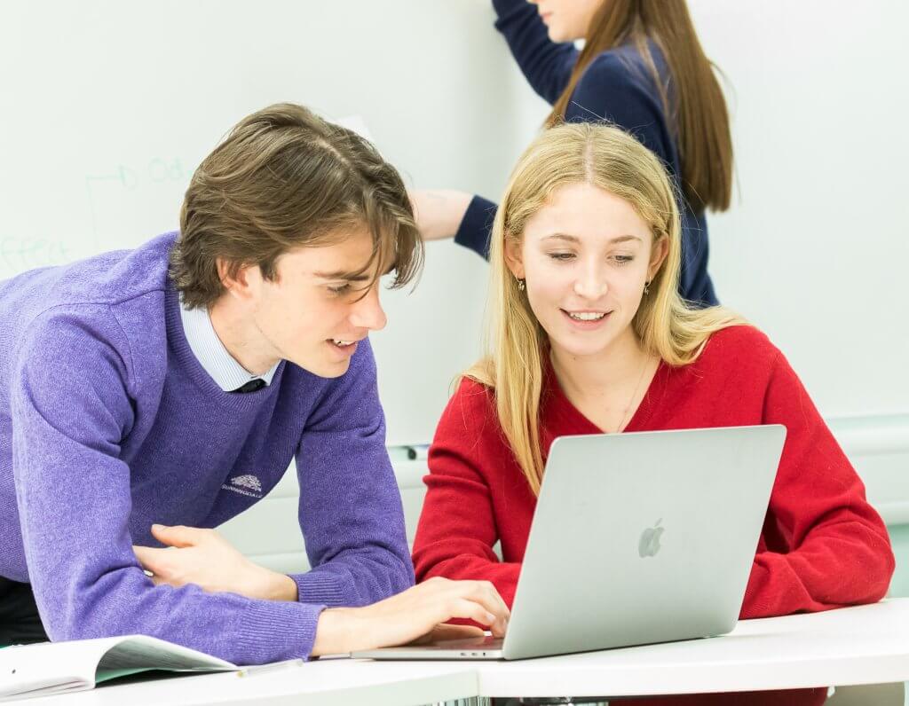 Boy and girl working together on laptop
